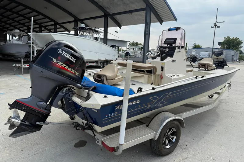 Slide: The Image of 2020 Xpress H20B boat with Yamaha outboard motor on a trailer in a marina. - 6
