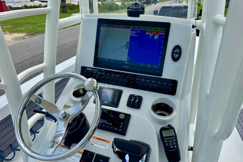 Slide: The Image of 2023 Pathfinder 2500 Hybrid boat dashboard with steering wheel and navigation display. - 12