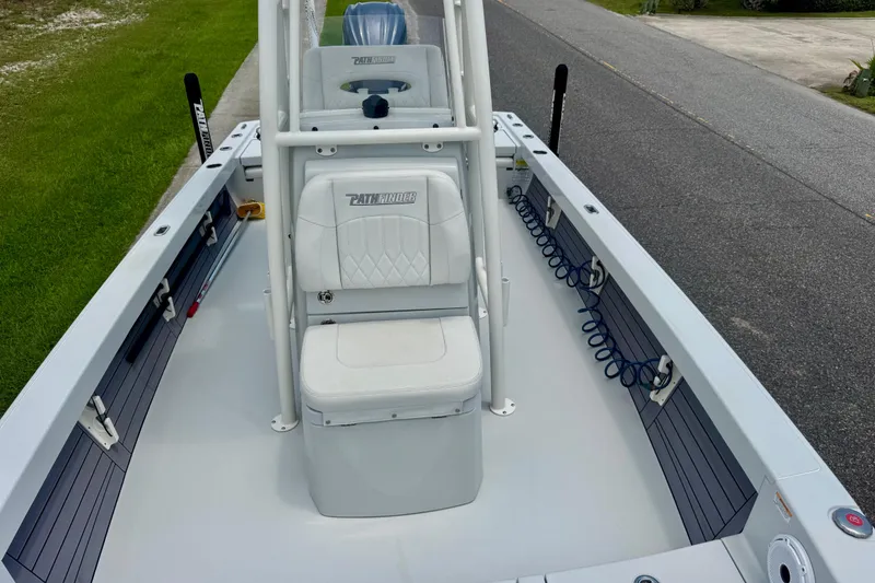 Slide: The Image of 2023 Pathfinder 2500 Hybrid boat interior with seating and storage, parked on a roadside. - 14
