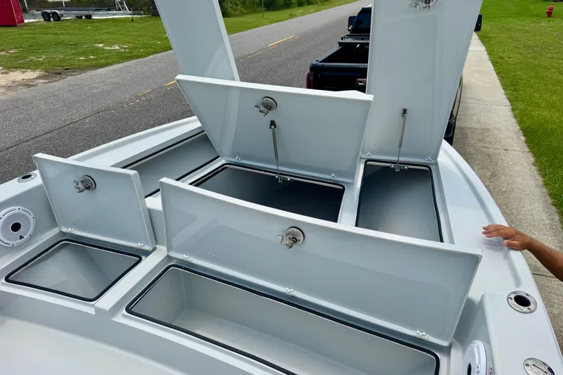 Slide: The Image of 2023 Pathfinder 2500 Hybrid boat with open storage compartments on a roadside. - 18