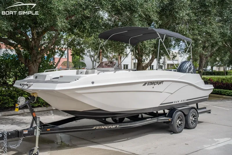 Slide: The Image of 2023 Starcraft SVX 231 OB DH boat on trailer, parked outdoors. - 0