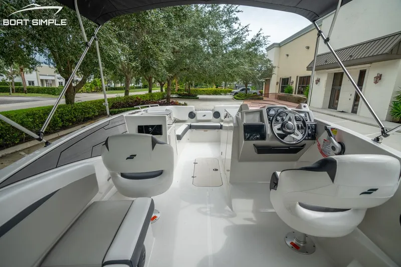 Slide: The Image of 2023 Starcraft SVX 231 OB DH boat interior with steering wheel and seating. - 12