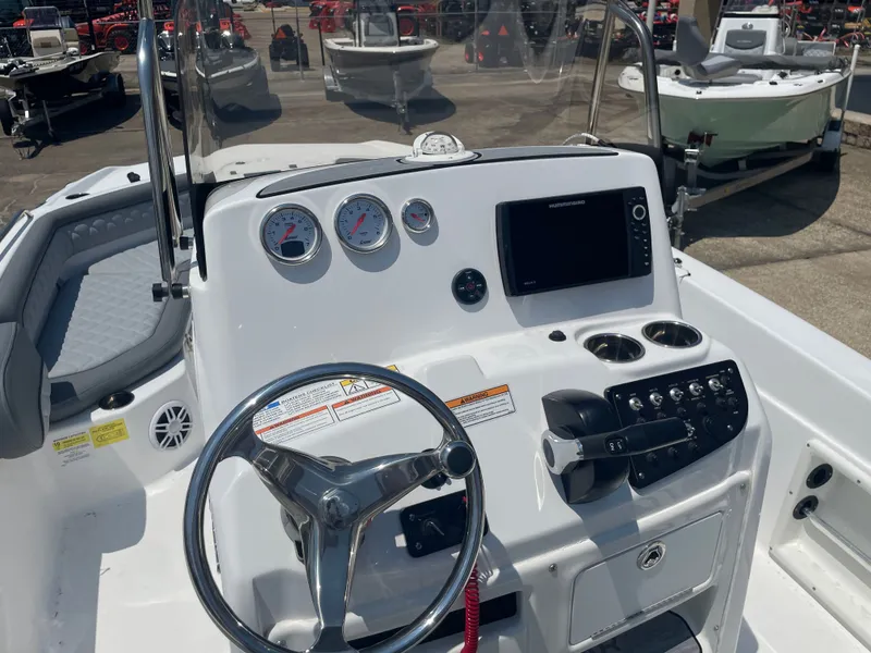 Slide: The Image of 2024 NauticStar 211 Hybrid boat dashboard with steering wheel and control panel. - 16