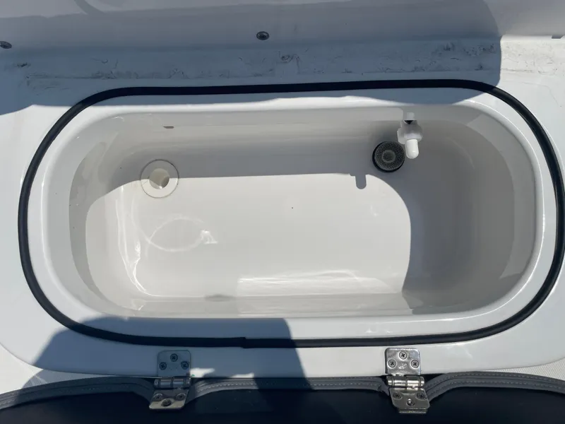 Slide: The Image of 2024 NauticStar 211 Hybrid livewell, open lid, white interior, boat accessory. - 17