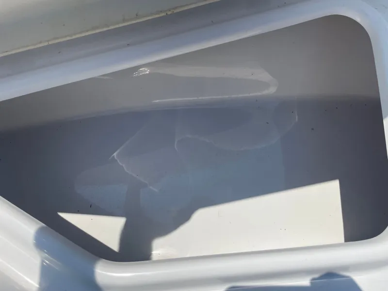 Slide: The Image of 2024 NauticStar 211 Hybrid boat storage compartment, white interior, close-up view. - 18