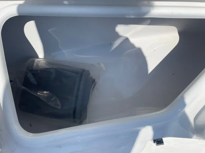 Slide: The Image of Storage compartment of 2024 NauticStar 211 Hybrid boat, featuring a clean, white interior. - 20