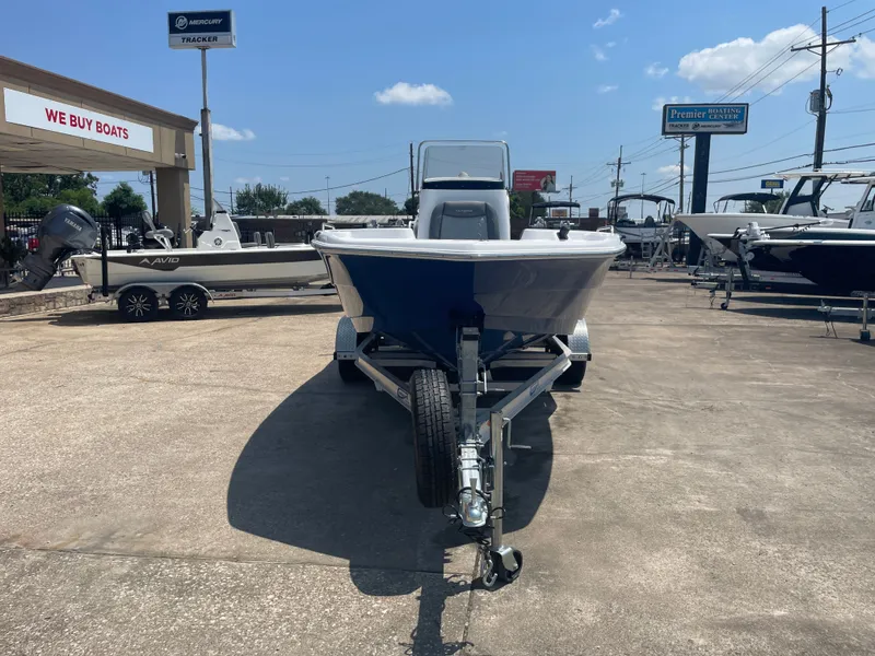 Slide: The Image of 2024 NauticStar 211 Hybrid boat on trailer at dealership under clear sky. - 5