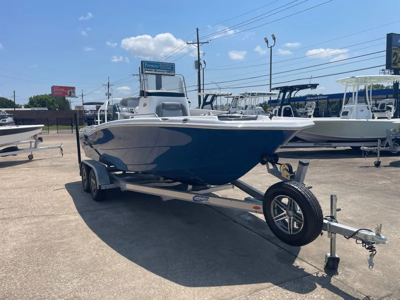 Slide: The Image of 2024 NauticStar 211 Hybrid boat on trailer, displayed outdoors under clear sky. - 6