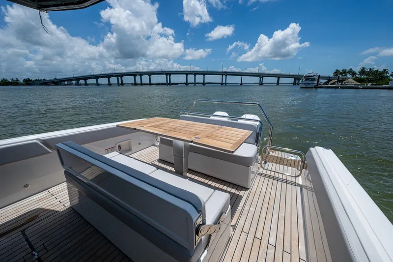 Slide: The Image of 2023 Schaefer V33 yacht deck with seating, table, and scenic bridge view. - 15