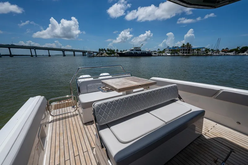 Slide: The Image of 2023 Schaefer V33 yacht deck with seating, table, and scenic waterfront view. - 18