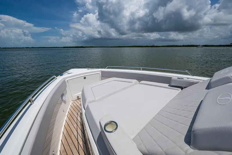 Slide: The Image of 2023 Schaefer V33 yacht deck with luxurious seating, overlooking serene waters and cloudy sky. - 21