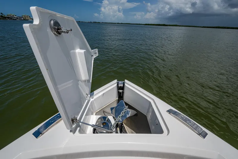 Slide: The Image of Open anchor compartment on 2023 Schaefer V33 boat, overlooking calm waters. - 26