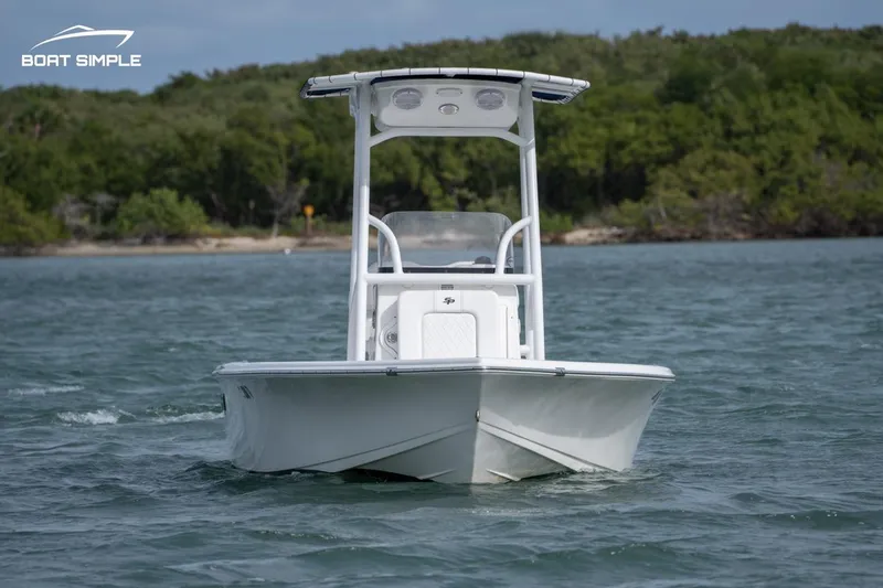 Slide: The Image of 2023 Sea Pro 208 Bay boat on water, surrounded by lush greenery. - 2