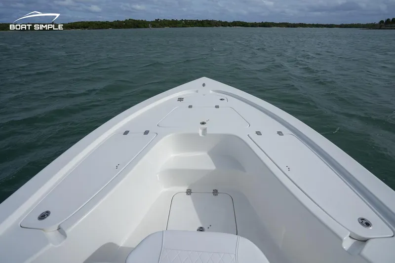Slide: The Image of 2023 Sea Pro 208 Bay boat on calm water, showcasing sleek design and spacious deck. - 5