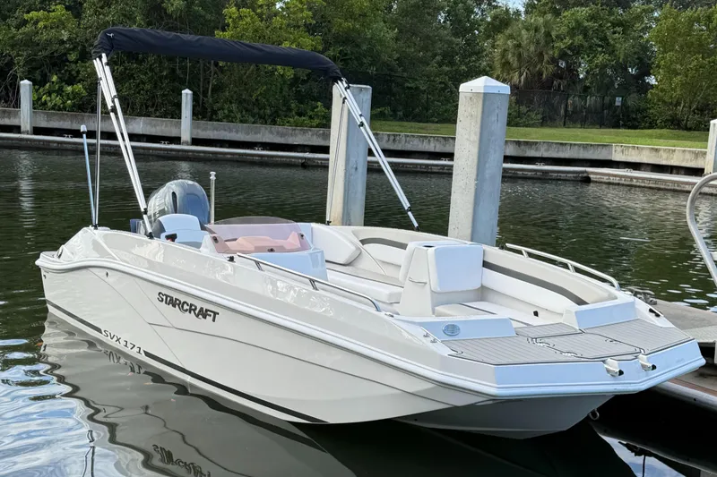 Slide: The Image of 2024 Starcraft SVX 171 OB boat docked in a serene marina setting. - 0