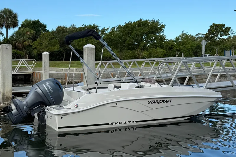 Slide: The Image of 2024 Starcraft SVX 171 OB boat docked near a marina with Yamaha outboard motor. - 1