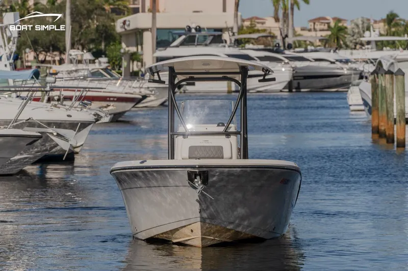 Slide: The Image of 2023 Cobia 220 Center Console boat docked in a marina. - 2