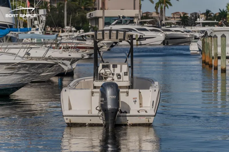 Slide: The Image of 2023 Cobia 220 Center Console boat docked in a marina. - 4