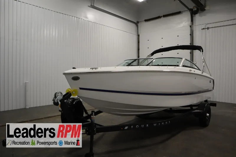 The Image of 2026 Four Winns H1 boat on trailer in indoor showroom. - 0
