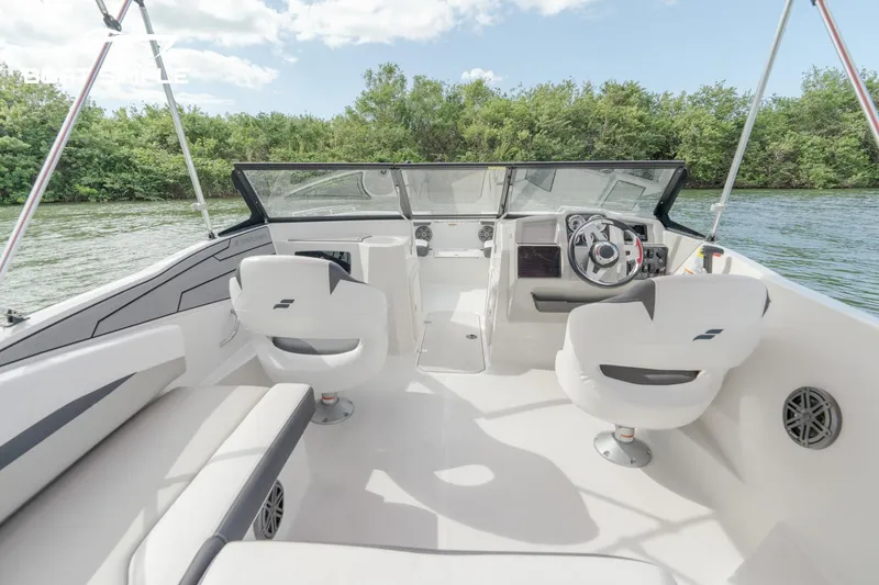 Slide: The Image of 2024 Starcraft SVX 210 OB DC boat interior with white seating and steering console. - 7