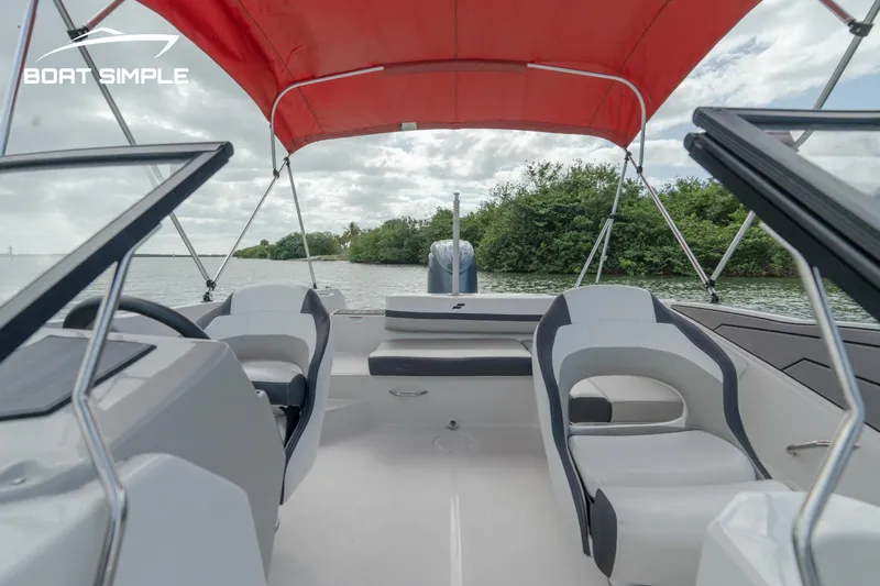 Slide: The Image of 2024 Starcraft SVX 210 OB DC boat with red canopy on a calm river. - 8