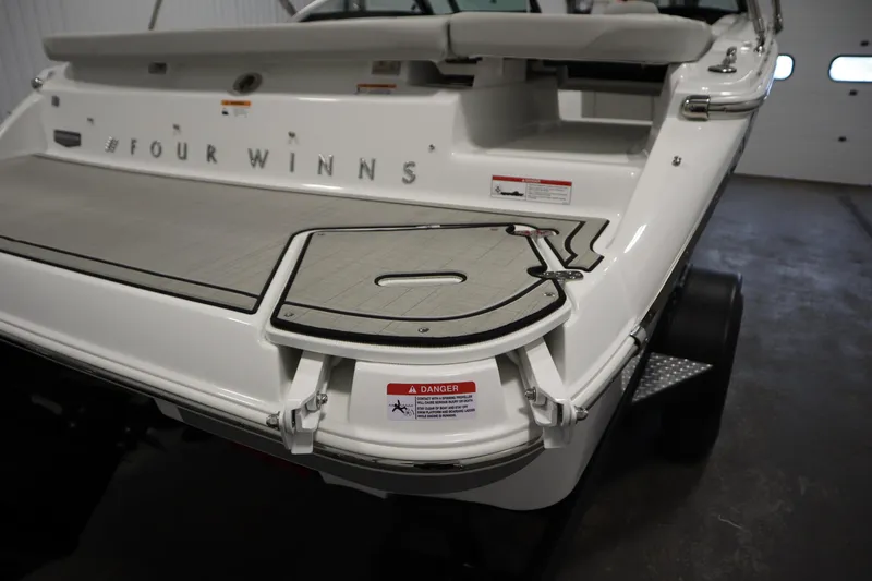 Slide: The Image of 2026 Four Winns H1 Freedom boat rear view in a garage setting. - 53