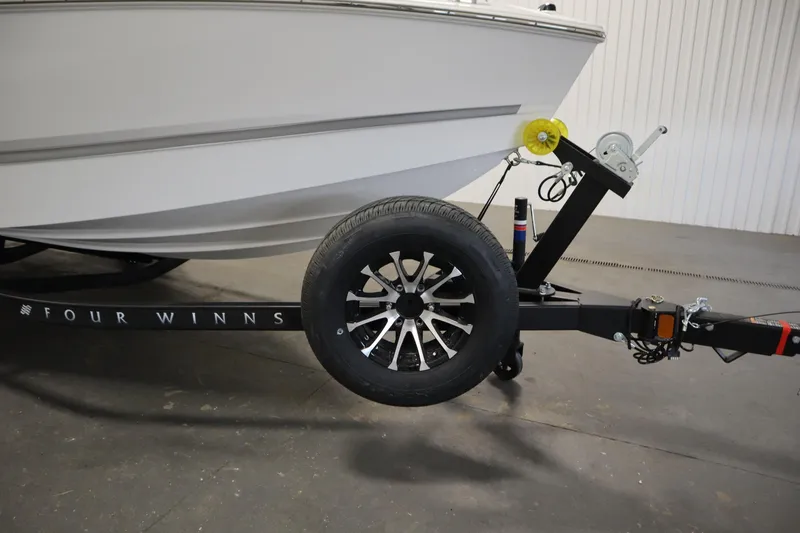Slide: The Image of 2026 Four Winns H1 Freedom boat on trailer, featuring sleek design and modern wheel. - 58