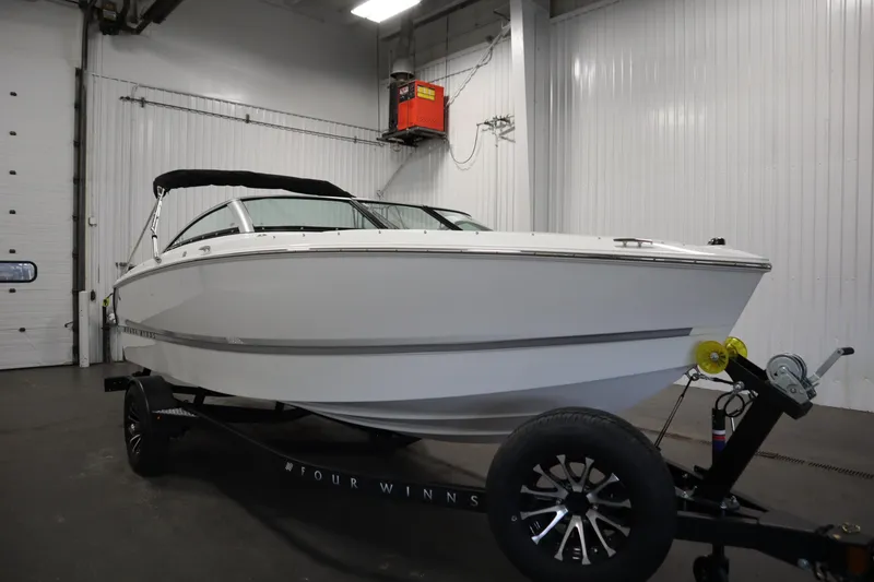 Slide: The Image of 2026 Four Winns H1 Freedom boat in a garage, on a trailer. - 6