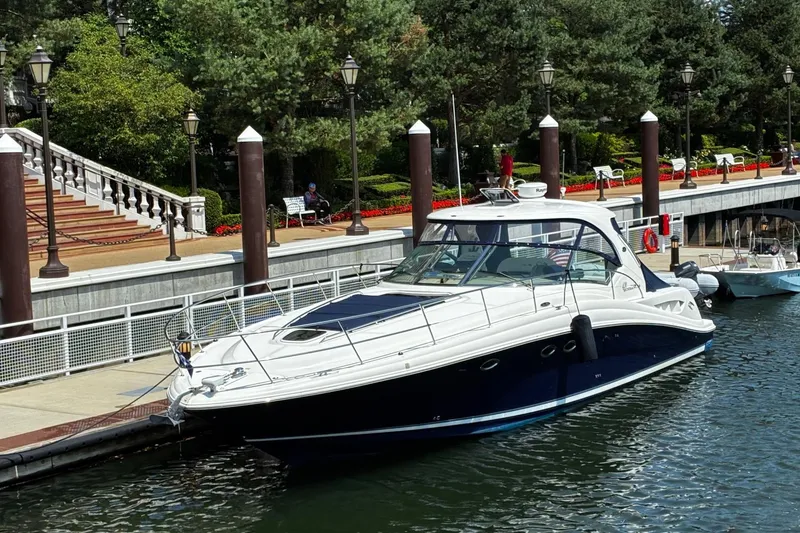 Slide: The Image of 2004 Sea Ray 420 Sundancer yacht docked at a scenic marina. - 10