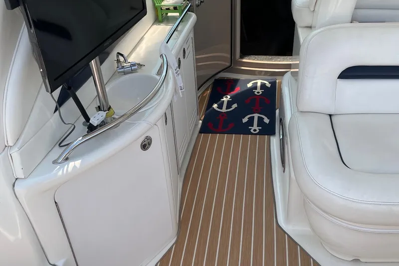 Slide: The Image of Interior of 2004 Sea Ray 420 Sundancer with TV, sink, and nautical-themed rug. - 12