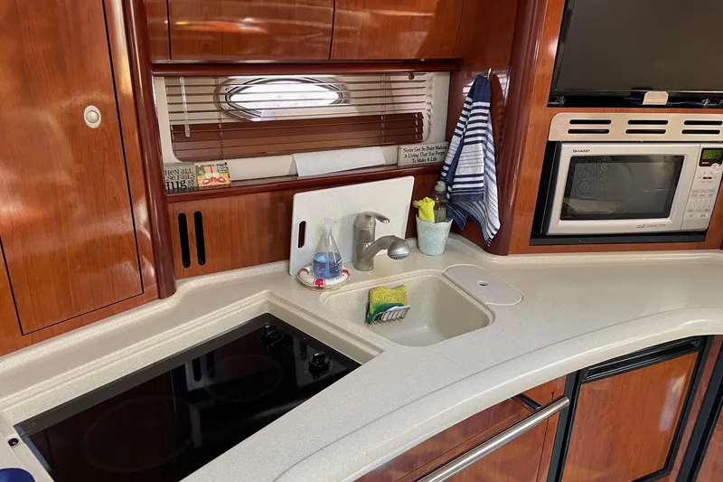 Slide: The Image of 2004 Sea Ray 420 Sundancer yacht kitchen with stove, sink, and microwave. - 18