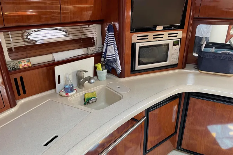 Slide: The Image of Luxurious 2004 Sea Ray 420 Sundancer yacht kitchen with microwave and sink. - 19