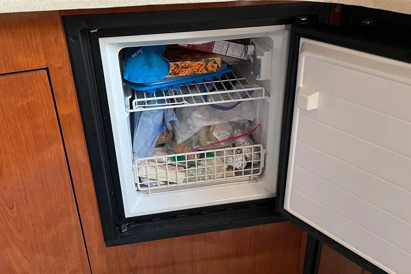 Slide: The Image of Freezer inside 2004 Sea Ray 420 Sundancer, stocked with various frozen foods. - 25