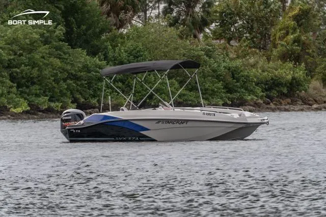 Slide: The Image of 2023 Starcraft SVX 171 OB boat on water, surrounded by lush greenery. - 1