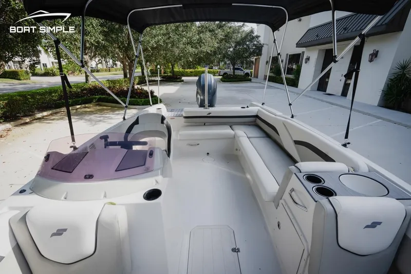 Slide: The Image of 2023 Starcraft SVX 211 OB boat interior with seating and console, parked outdoors. - 14