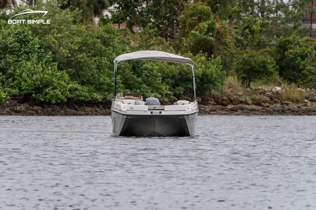 Slide: The Image of 2023 Starcraft SVX 231 OB DH boat on a calm lake with lush greenery. - 3