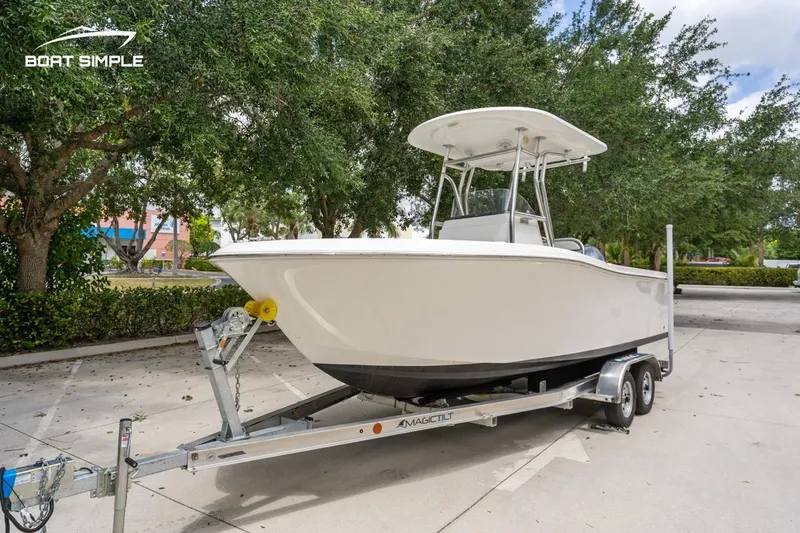 Slide: The Image of 2020 Release 210 RX boat on trailer, parked outdoors with trees in background. - 4