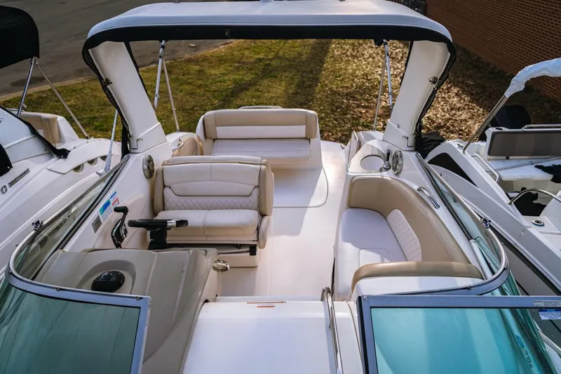 Slide: The Image of 2018 Chaparral 270 Signature boat interior with seating and canopy, docked outdoors. - 9