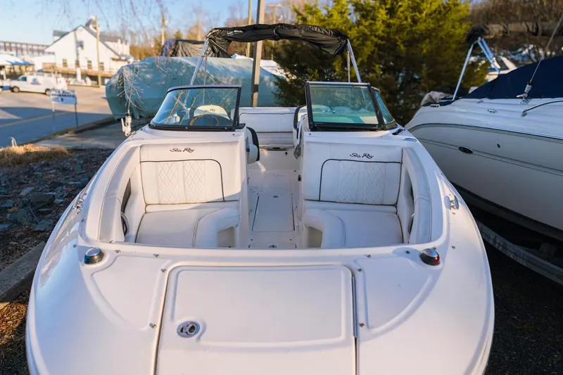 Slide: The Image of 2015 Sea Ray 220 Sundeck boat with white seating, docked outdoors. - 2