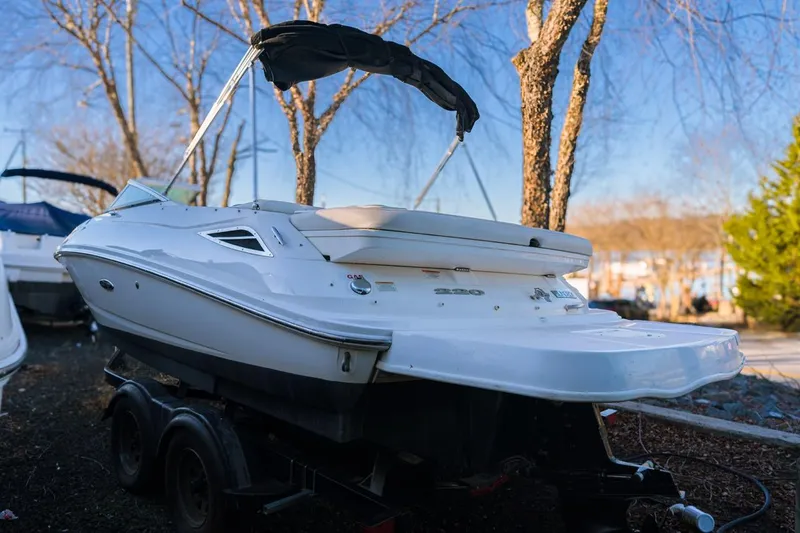 Slide: The Image of 2015 Sea Ray 220 Sundeck boat on trailer, parked outdoors. - 3