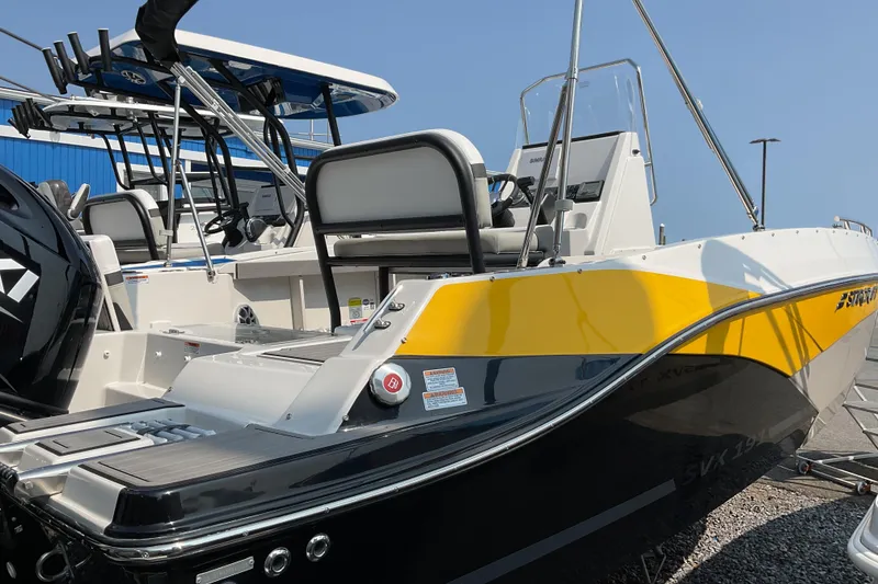 Slide: The Image of 2025 Starcraft SVX 191 OB CC boat with yellow and black design, docked outdoors. - 1