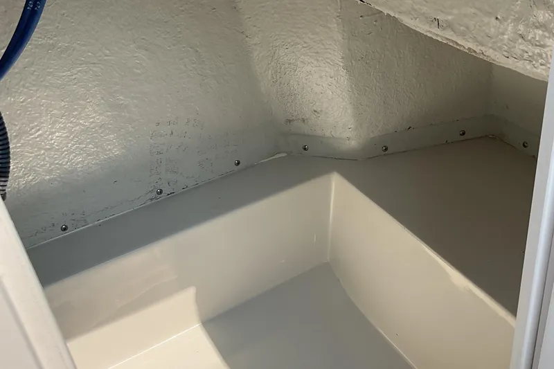 Slide: The Image of 2025 Starcraft SVX 191 OB CC boat storage compartment, white interior, clean and spacious. - 22