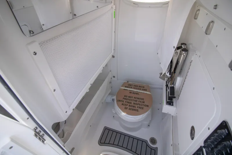 Slide: The Image of Interior of 2026 Sea Hunt Ultra 265 SE boat bathroom with toilet and storage. - 13
