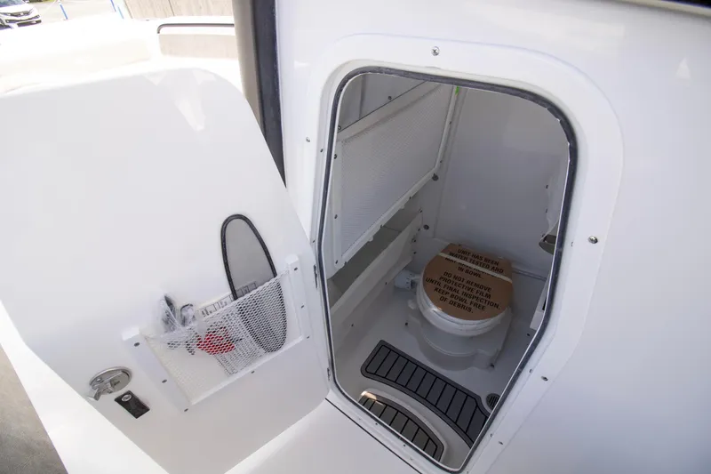Slide: The Image of 2026 Sea Hunt Ultra 265 SE boat interior with compact marine toilet. - 14