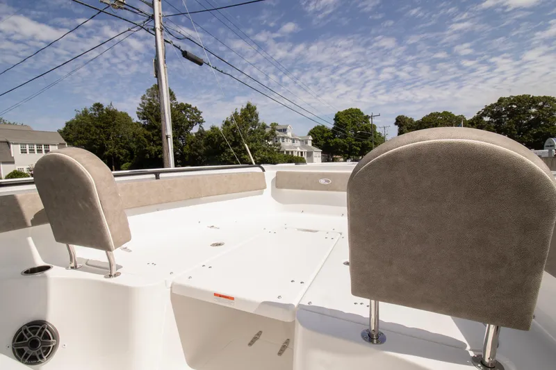 Slide: The Image of 2026 Sea Hunt Ultra 265 SE boat interior with cushioned seating under a clear sky. - 9