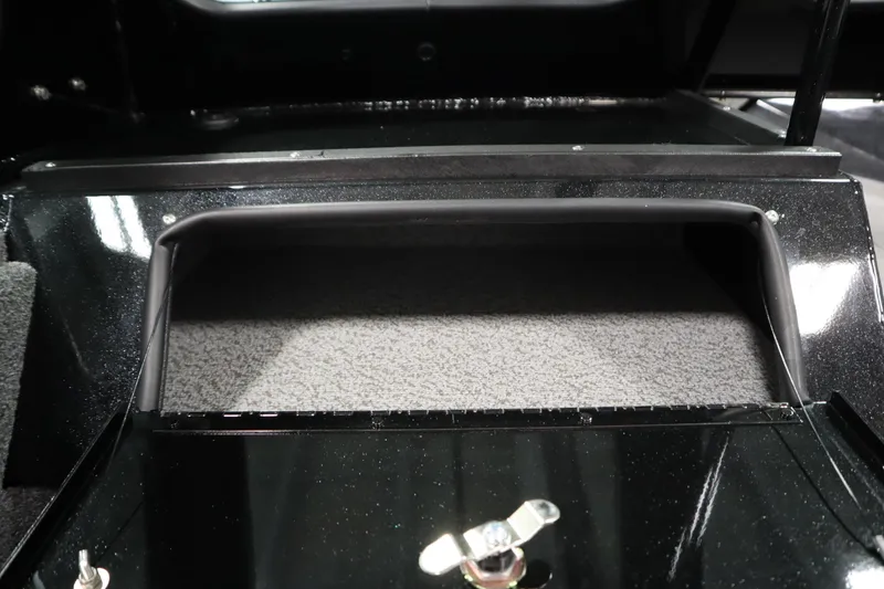 Slide: The Image of 2026 Crestliner 2050 Commander storage compartment with carpeted interior and secure latch. - 24