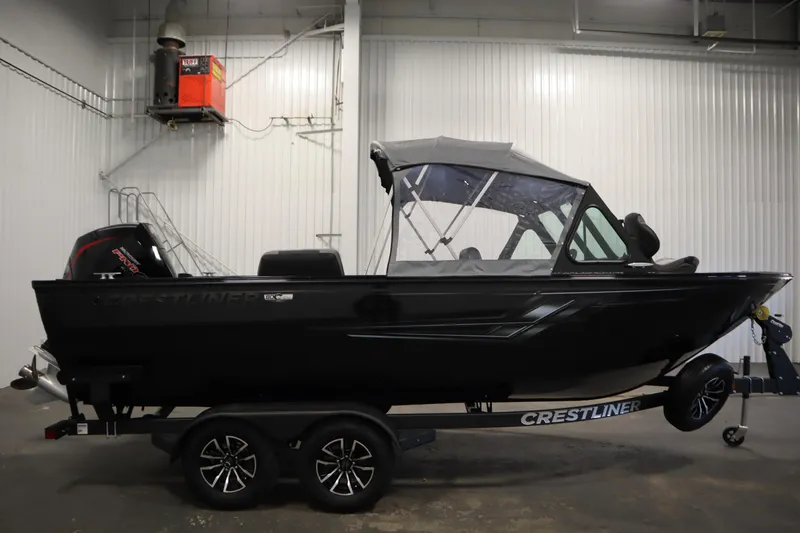 Slide: The Image of 2026 Crestliner 2050 Commander boat in a showroom, side view with trailer. - 43