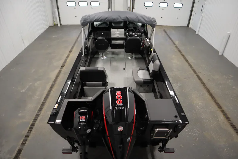 Slide: The Image of 2026 Crestliner 2050 Commander boat in a garage, featuring a Mercury V8 engine. - 9