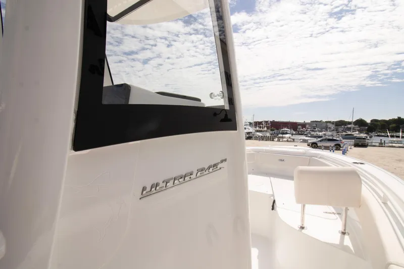 Slide: The Image of 2026 Sea Hunt Ultra 245 SE boat docked under a partly cloudy sky. - 4