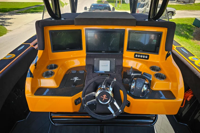 Slide: The Image of Orange dashboard of 2016 Statement 380 Open boat with multiple screens and controls. - 10